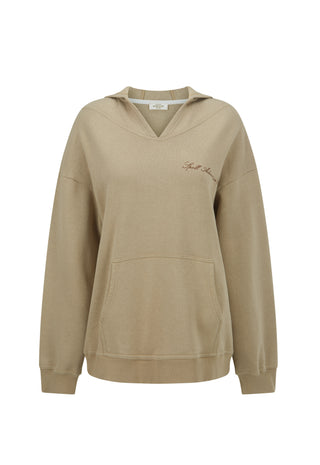 A beige pullover hoodie with a V-neck, kangaroo pocket, and subtle script embroidery on the left chest, displayed against a plain white background.